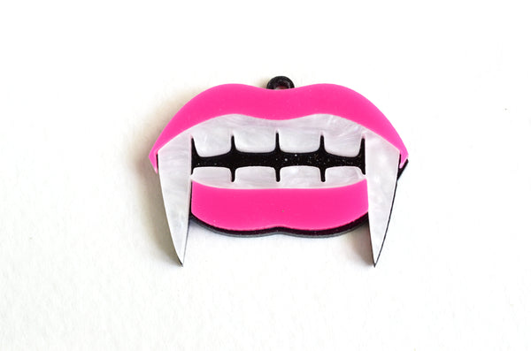 Pink mouth with white pearly vampire fangs and teeth