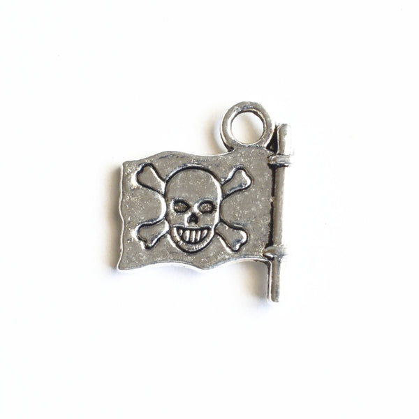 silver flag charm with a skull and crossbone design stamped onto the metal