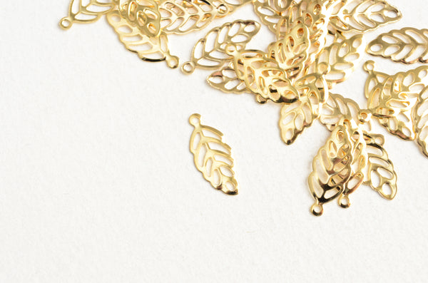 small shiny gold plated leaf charms. Leaves have a cutout design with 9 holes cut out and have a single loop at the top of the leaf