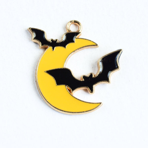 Yellow crescent moon charm with one flying bat on the left and a larger flying bat on the right