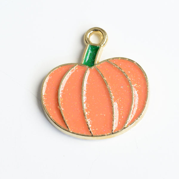 Orange glitter pumpkin charm with a green enamel stem